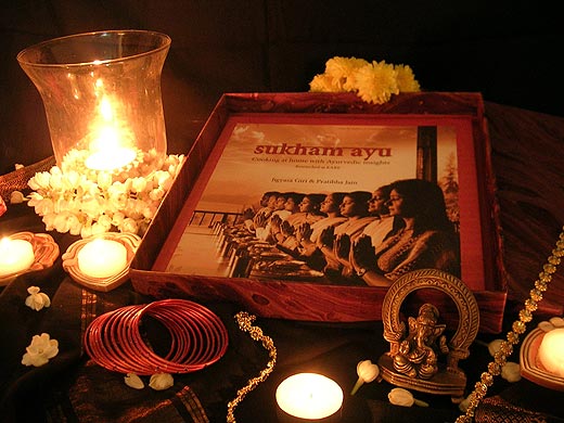 Traditional Indian gift adorned with soft candle light chimney, jasmine & chrysanthemum flowers, ausicious Ganesha & bangles