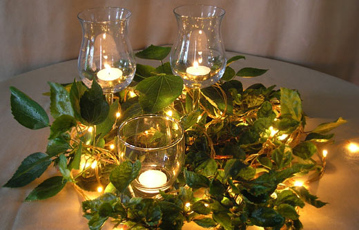 Simple Festival Table Arrangement with Leaf Branches, Glass Votives, Wine Glasses and Tealights